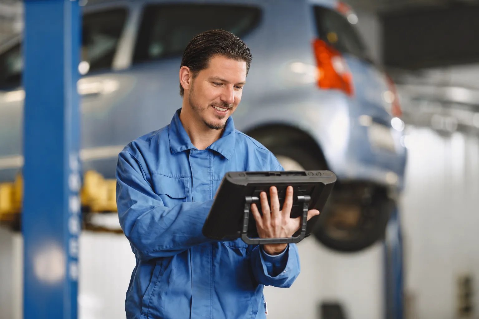 Bildmotiv mit Christopher Gärtner und Tablet in der Werkstatt